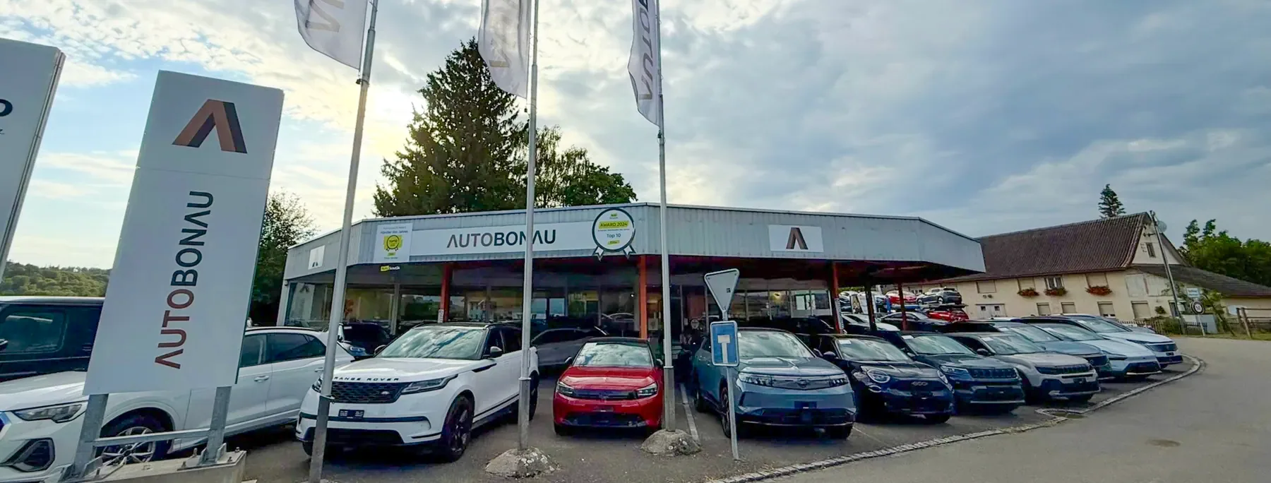 Auto Bonau AG in Bonau mit Fahrzeugauswahl und Fahnen